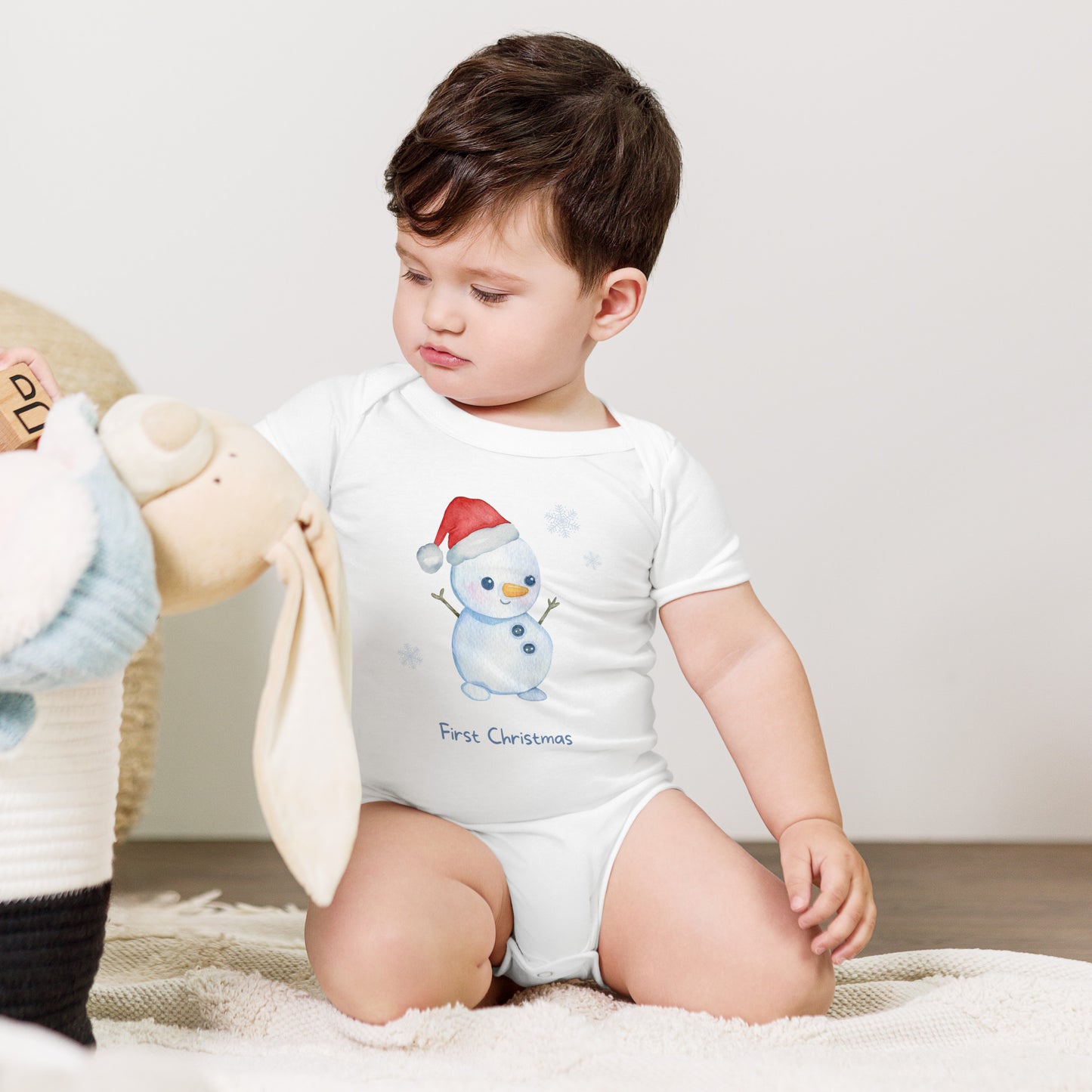 baby onesie with 'first christmas' text and cute santa snowman graphic