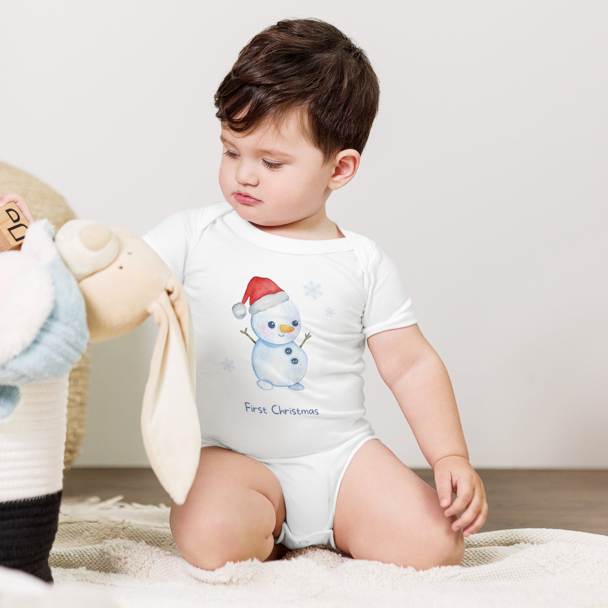 baby onesie with 'first christmas' text and cute santa snowman graphic