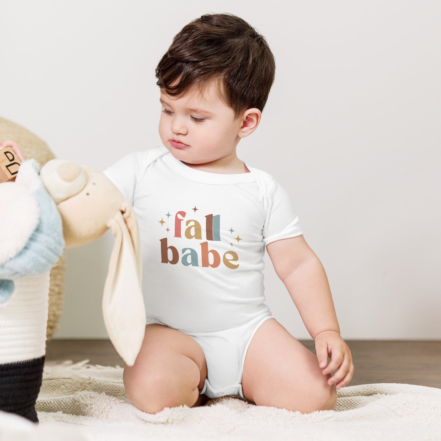 baby onesie with 'fall babe' text design in autumn colors