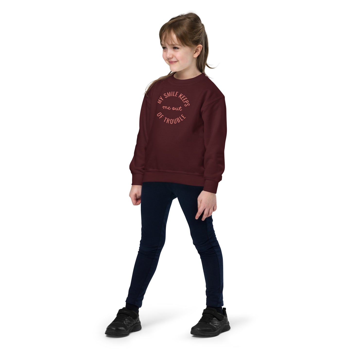 youth crew neck sweatshirt with 'My Smile Keeps Me Out of Trouble' text design