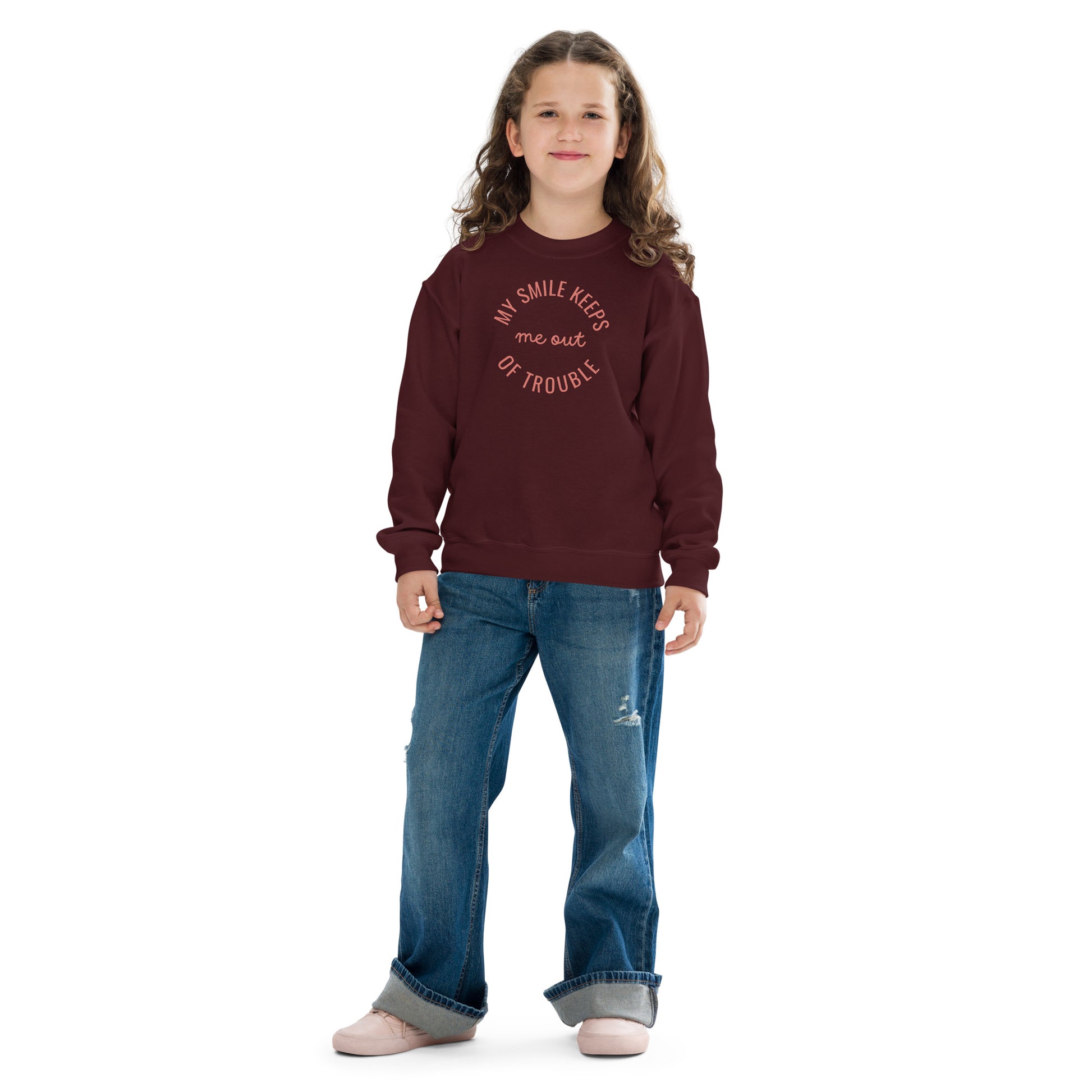 youth crew neck sweatshirt with 'My Smile Keeps Me Out of Trouble' text design