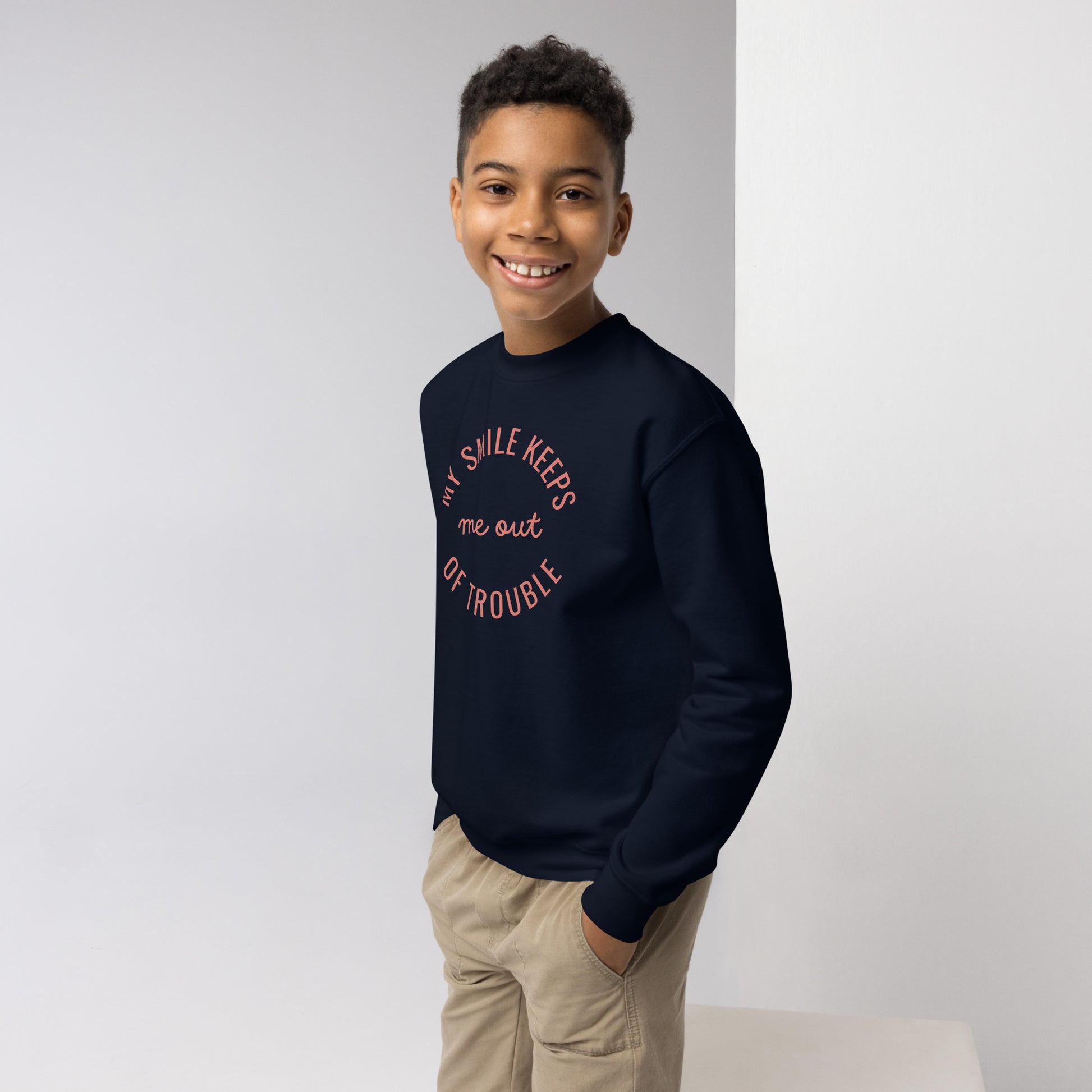 youth crew neck sweatshirt with 'My Smile Keeps Me Out of Trouble' text design