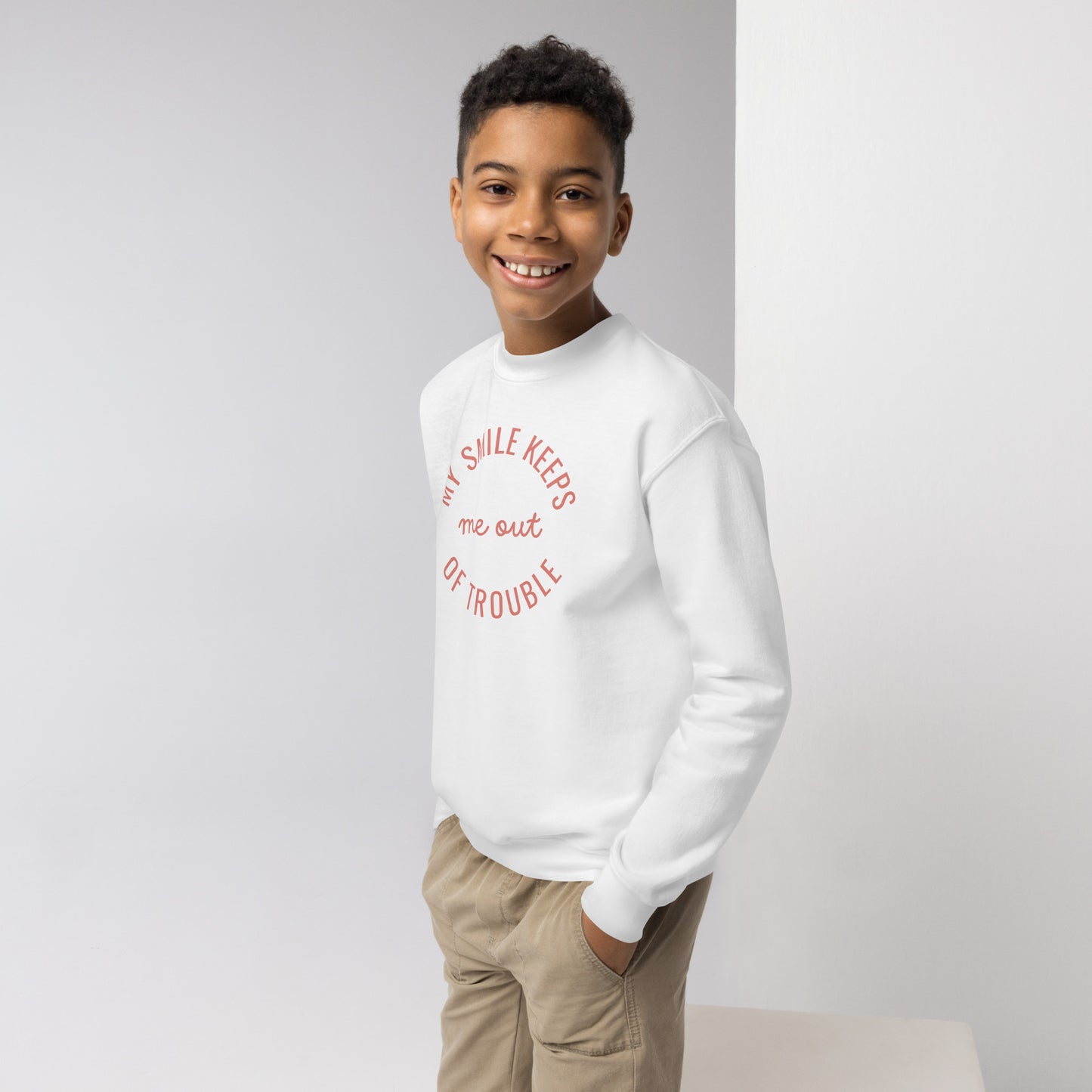youth crew neck sweatshirt with 'My Smile Keeps Me Out of Trouble' text design