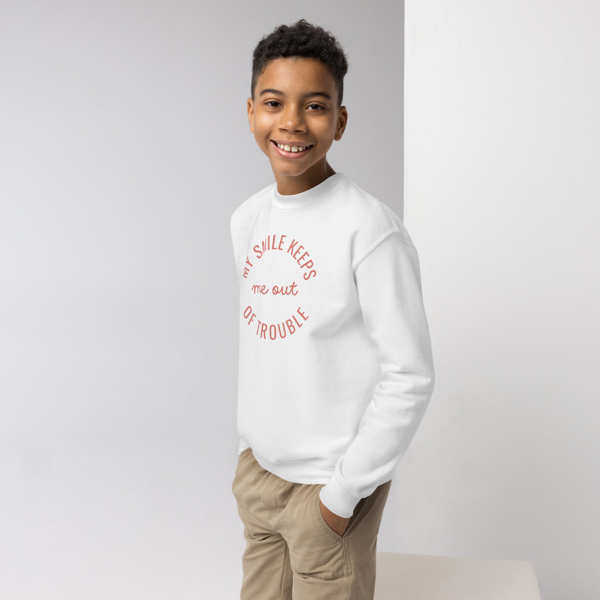 youth crew neck sweatshirt with 'My Smile Keeps Me Out of Trouble' text design
